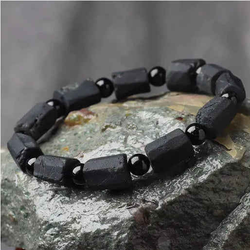 Unisex black tourmaline rough stone bracelet on wrist, showing natural texture and 10mm band width.