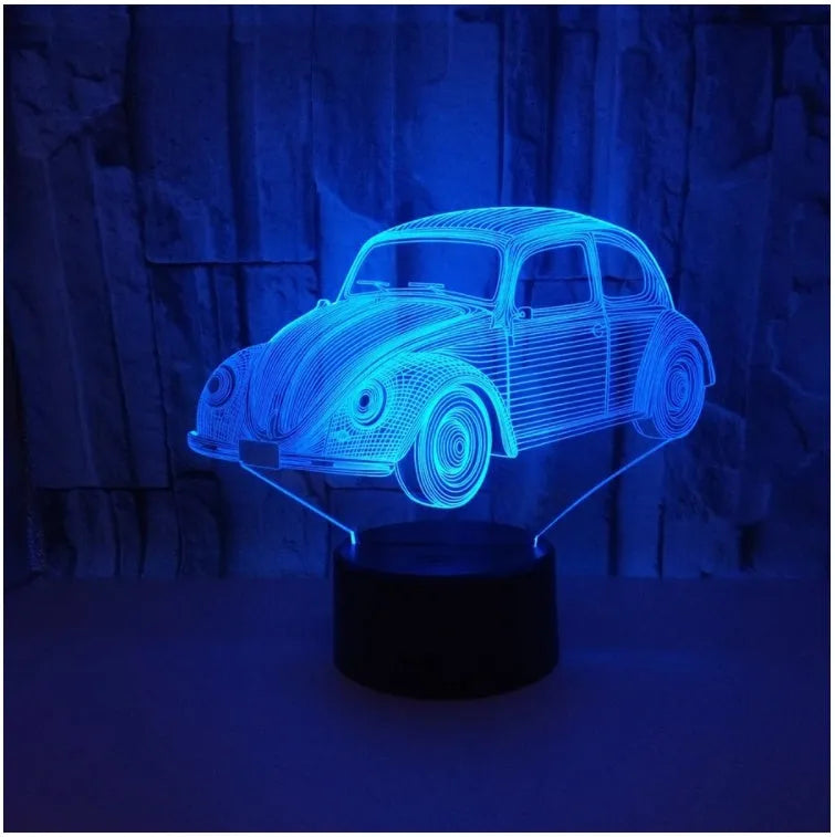 Small modern table lamp with colourful LED light and remote control on a desk.