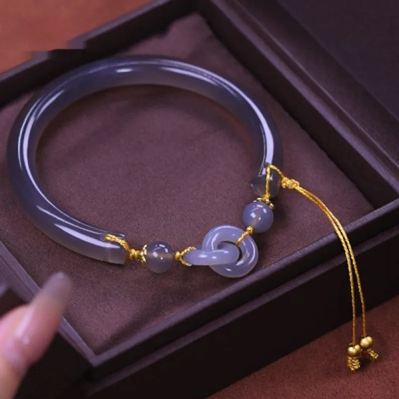 Close-up of a smoke purple grey agate half bracelet with a metal ring buckle closure on a wrist.