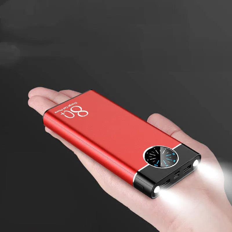 Black fast charging 20000mAh power bank with alloy shell and LED flashlight on a table.