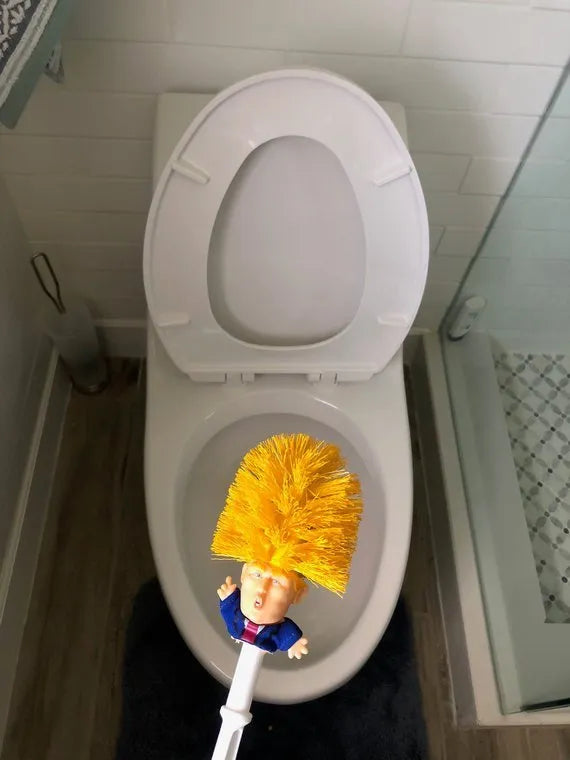 Yellow plastic Trump novelty toilet brush with a hanging slot on the handle.