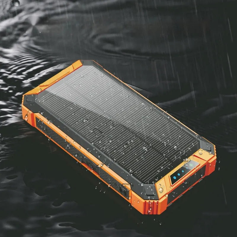 Red and black solar power bank with wireless charging pad showing size comparison to a mobile phone.