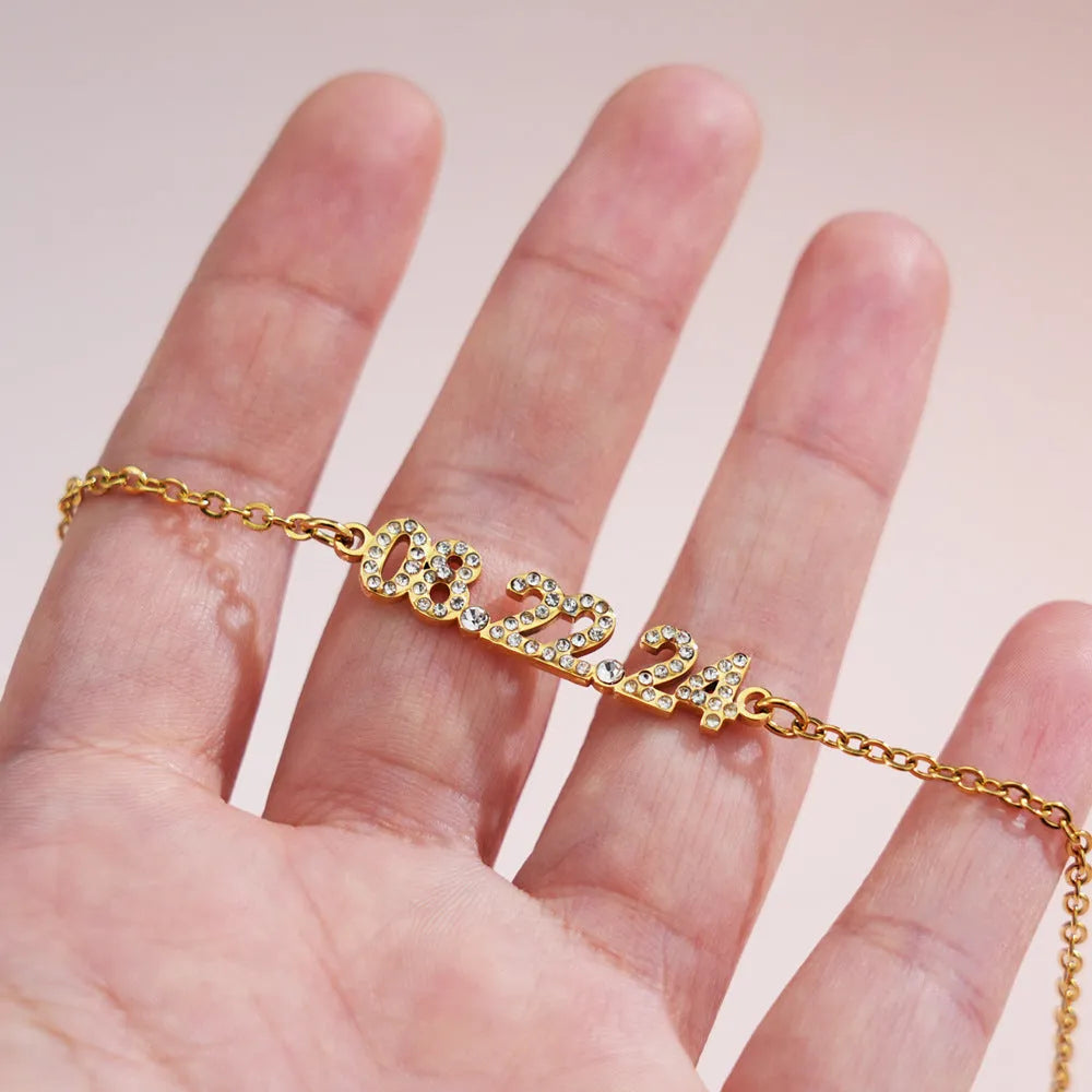 Stainless steel digital bracelet with crystal-set bezel showing time display, alongside matching necklace option.