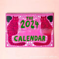 Cat-themed wall calendar showing 12-month grid with tear-off design and feline illustrations for each month