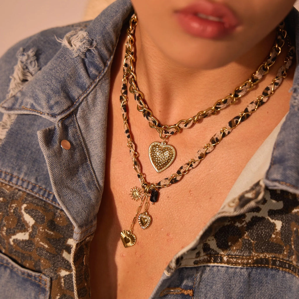 Close-up of a stainless steel necklace with a geometric leopard love pendant on an adjustable 18K-plated chain.