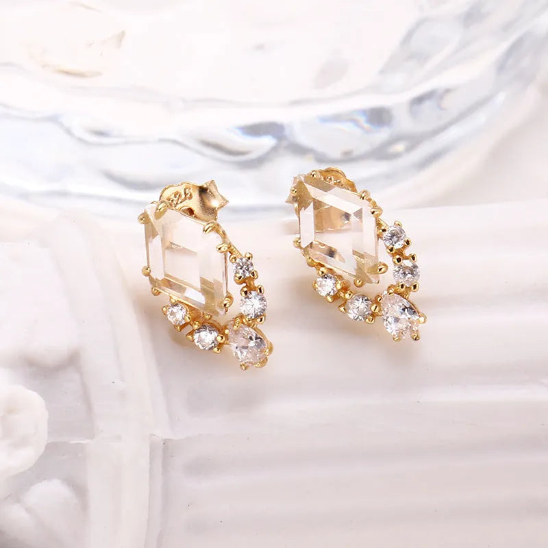 Geometric silver earrings with sweet white crystal studs showing structured design