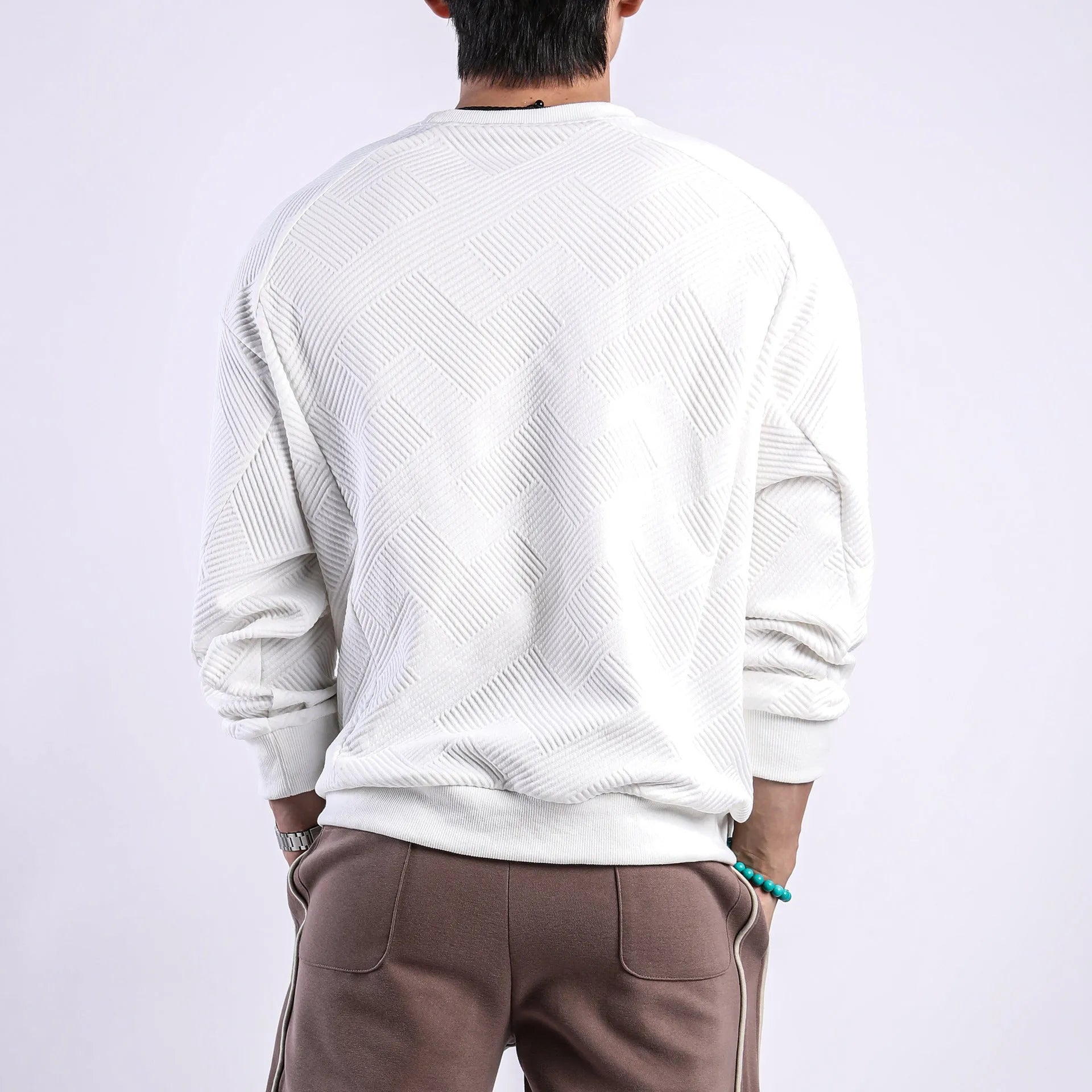 Men's solid colour long-sleeved sweater in twill jacquard fabric, shown in a loose fit with a round neck.