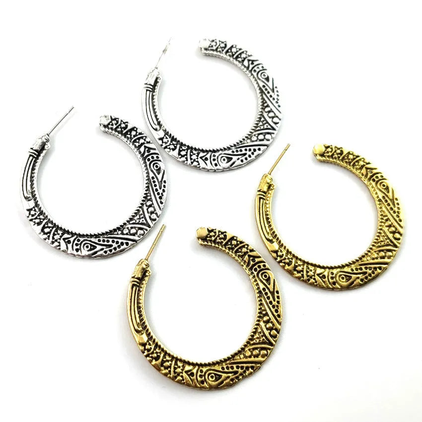 Pair of bronze C-shaped alloy earrings with detailed vintage engraving on the surface.