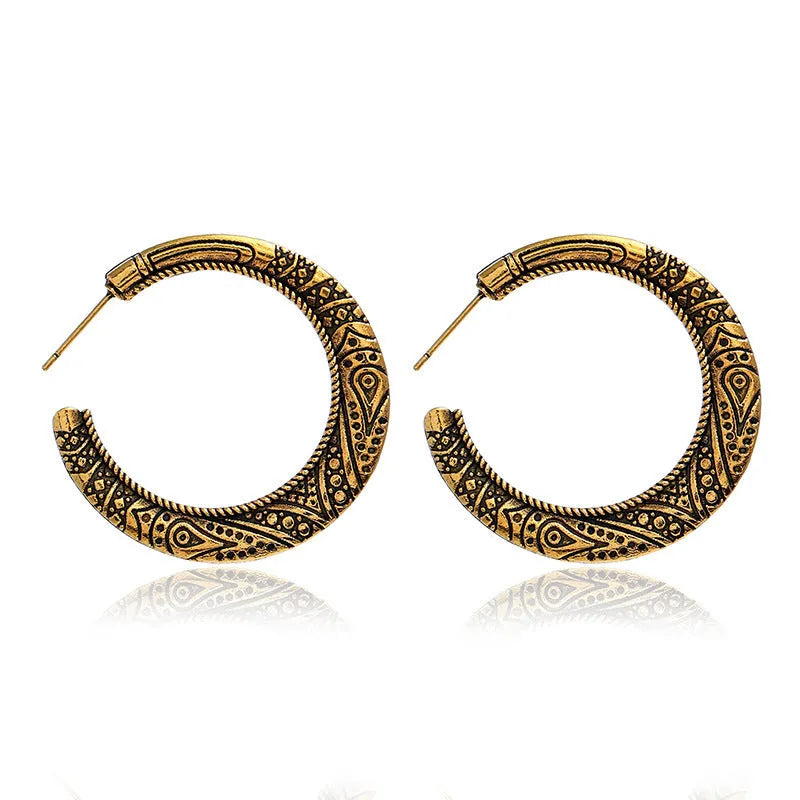 Pair of bronze C-shaped alloy earrings with detailed vintage engraving on the surface.