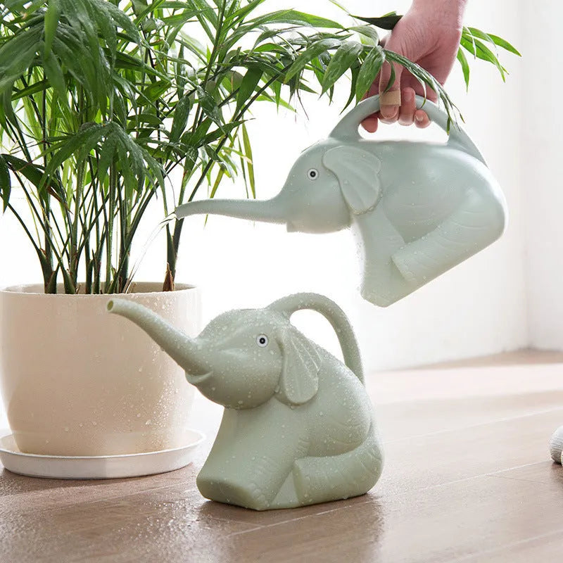 A pink plastic watering can shaped like a sitting baby elephant with a long spout.