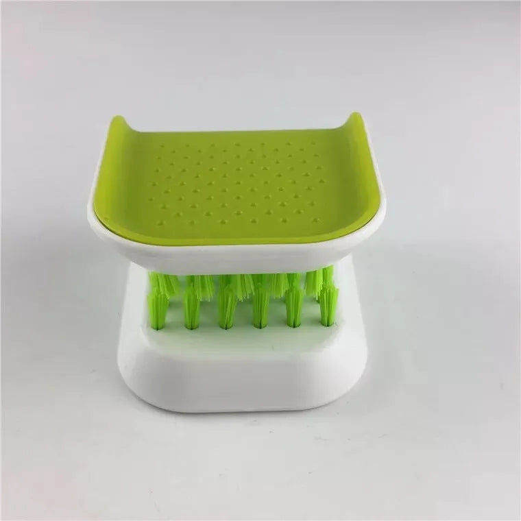 Blue U-shaped plastic brush for cleaning kitchen knives and cutlery on a kitchen counter.