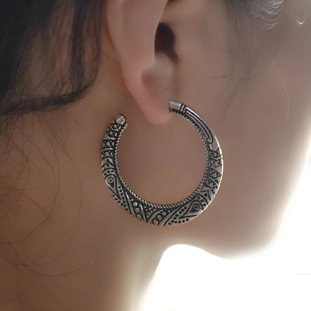 Pair of bronze C-shaped alloy earrings with detailed vintage engraving on the surface.