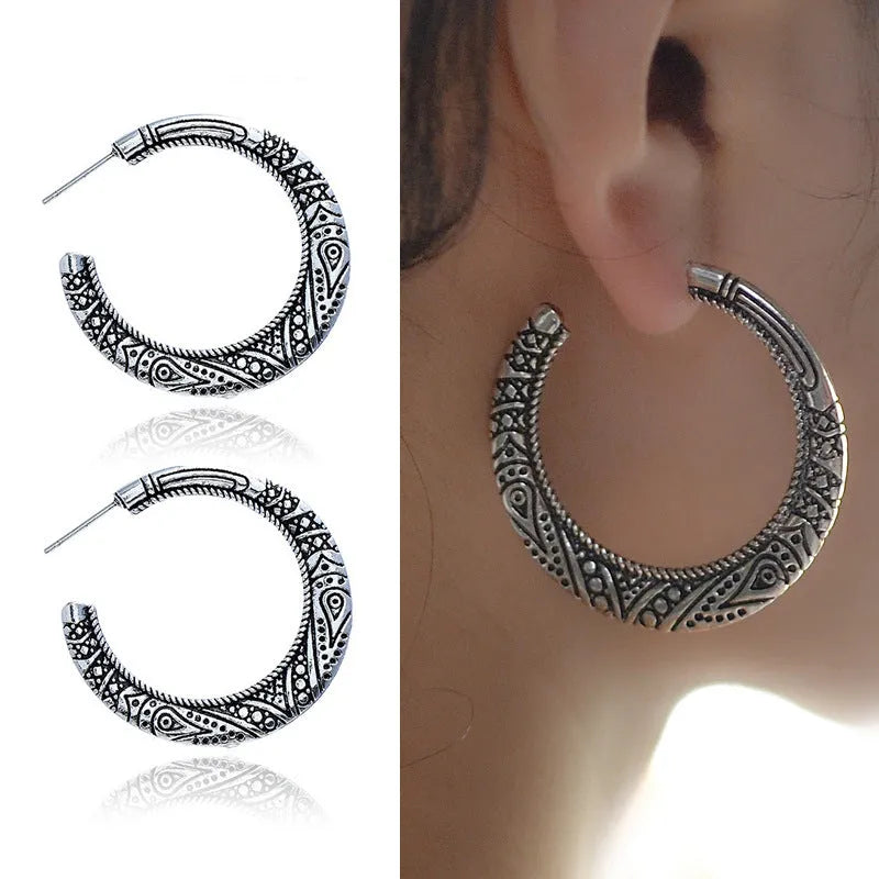 Pair of bronze C-shaped alloy earrings with detailed vintage engraving on the surface.