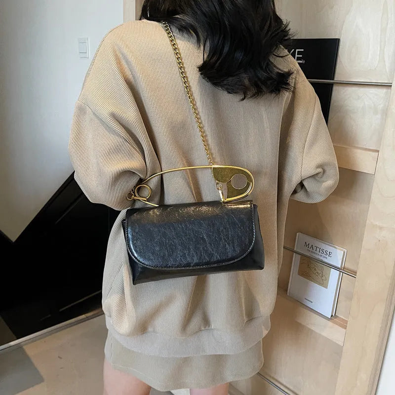Black street trend shoulder handbag with sandwich pockets and visible sewing thread details.