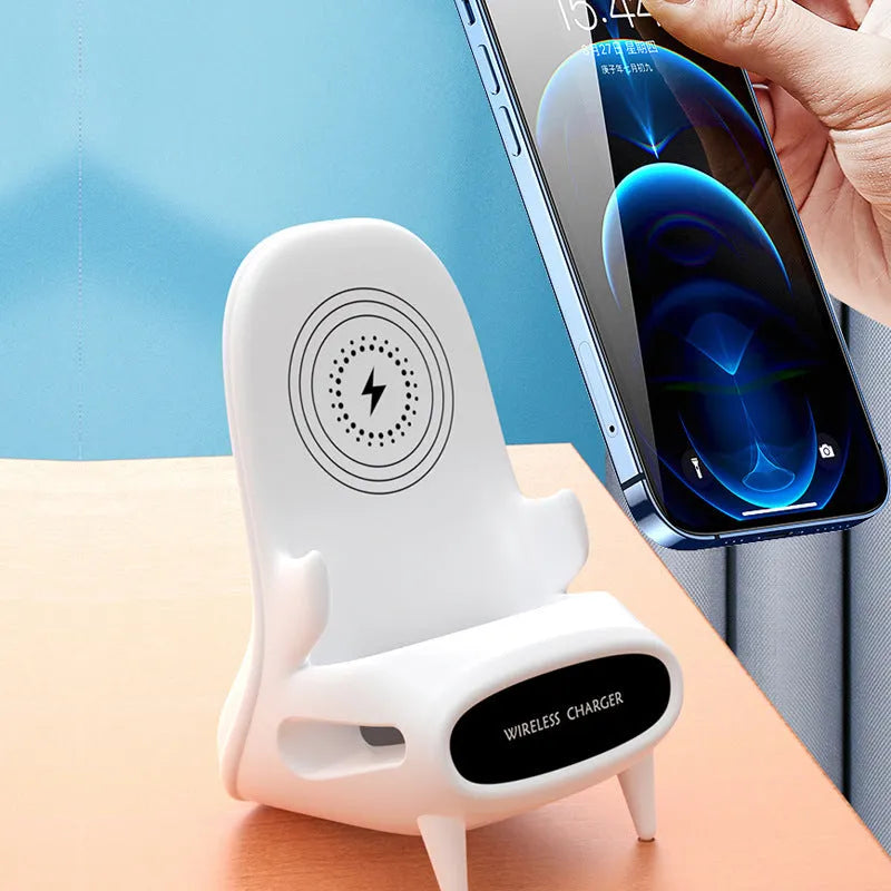 White mini chair shaped wireless charging stand holding smartphone on desk