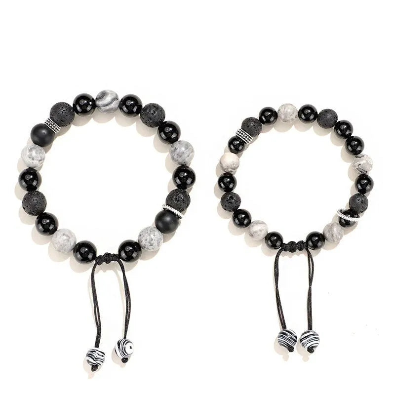 Black agate map stone volcanic rock bracelet with diamond-shaped beads on a wrist.