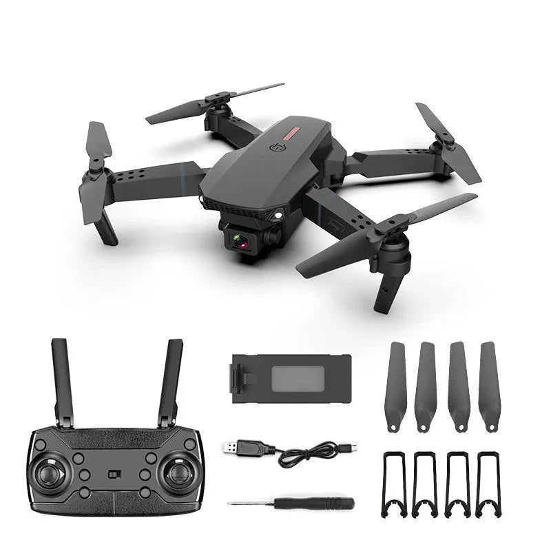 Grey foldable 4K aerial drone with dual cameras and remote control on a grassy field.