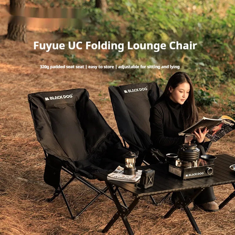 Black folding camping recliner with Oxford cloth seat, shown in outdoor setting