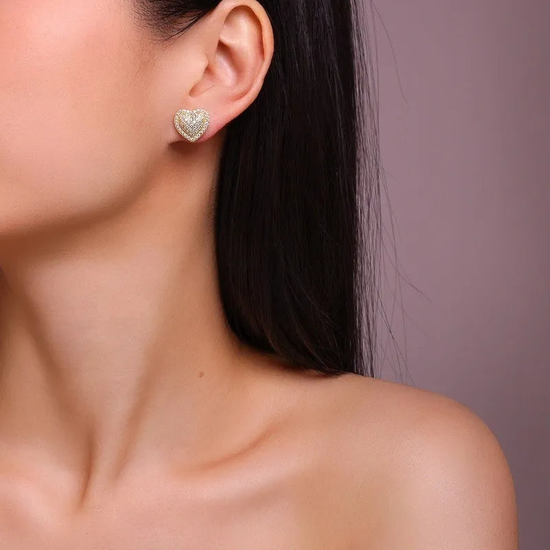 Golden heart-shaped moissanite stud earrings with sterling silver posts and butterfly backs
