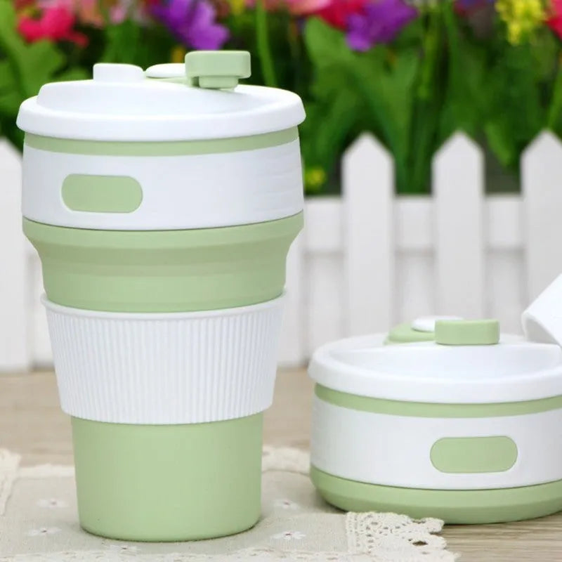Green collapsible silicone travel cup folded to 6cm height next to expanded 350ml version with leak-proof cover