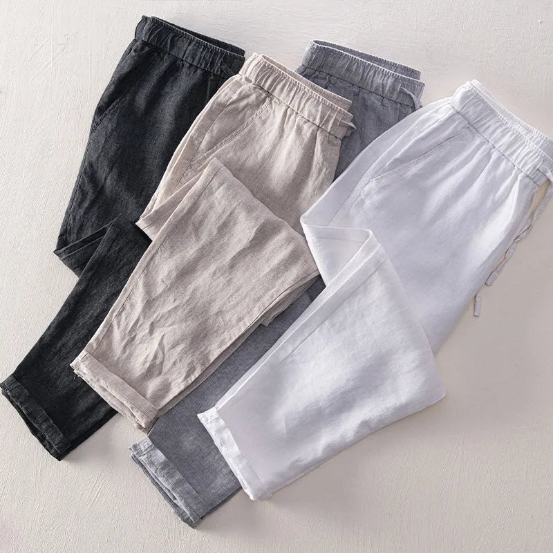 Men's straight-leg linen trousers in dark grey, showing the mid-waist and relaxed leg fit