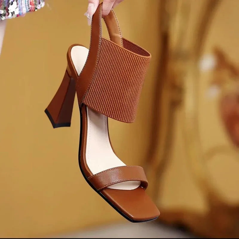 Women's black heeled sandals with elastic straps showing adjustable design