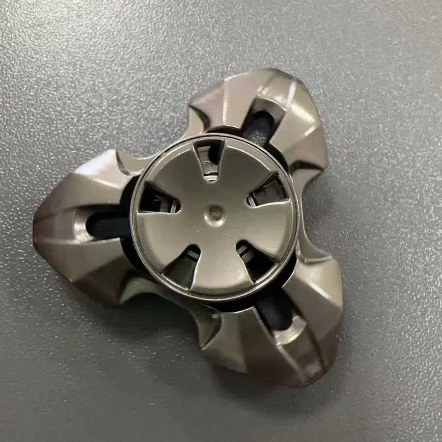 Alloy metal decompression rotating fingertip gyro toy in gun colour and colourful options on a solid background.