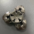 Alloy metal decompression rotating fingertip gyro toy in gun colour and colourful options on a solid background.