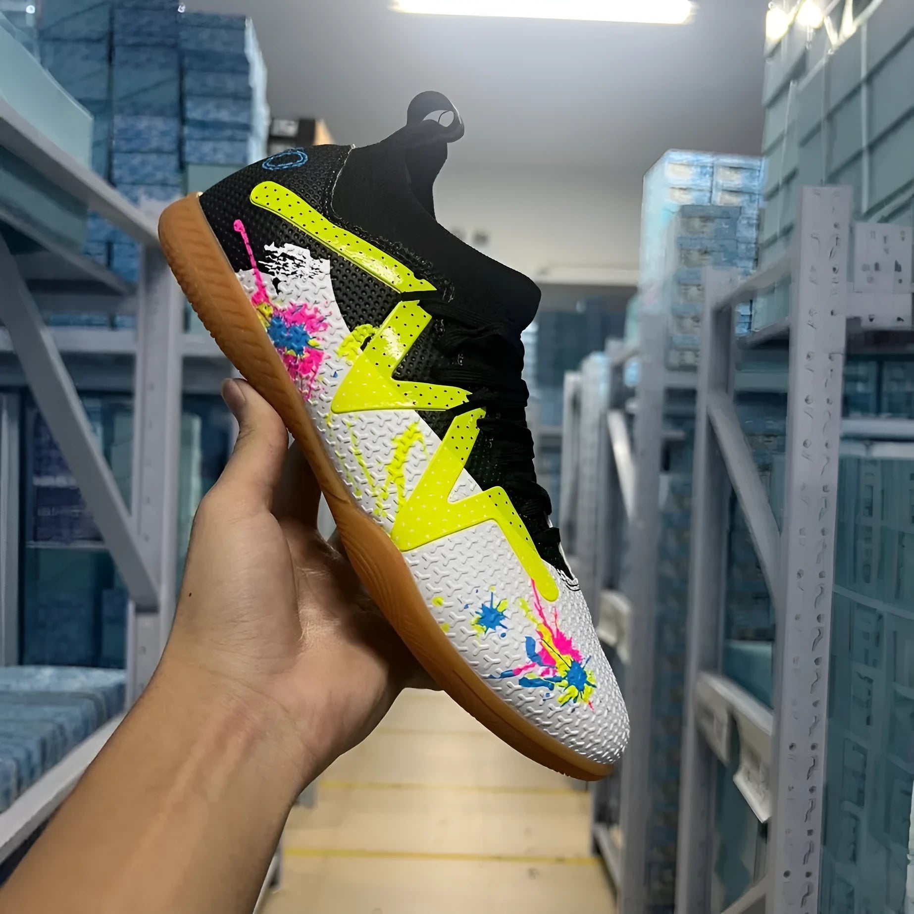 Men's low-top football boots with replaceable screw-in studs, in black and yellow colourway