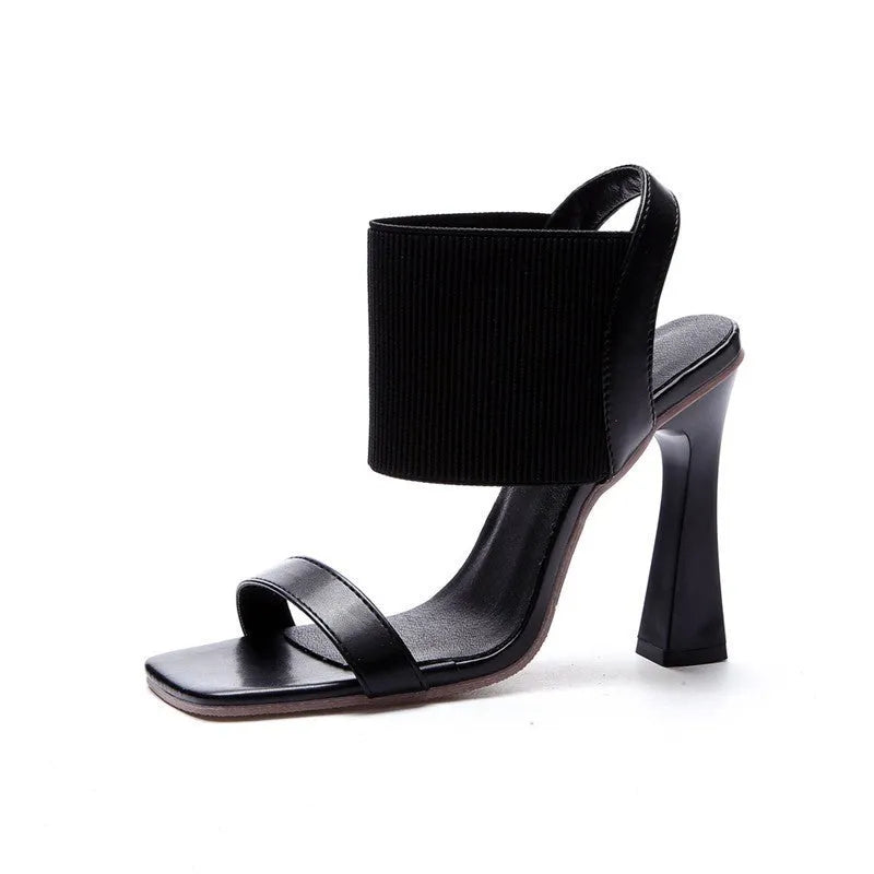 Women's black heeled sandals with elastic straps showing adjustable design