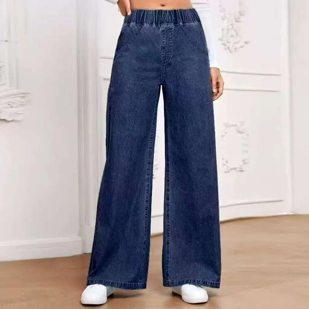 Light blue washed wide-leg straight jeans with mid-waist design and zip placket closure on hanger