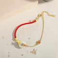 Gold electroplated 925 silver women's bracelet with koi and peace buckle design on adjustable red rope