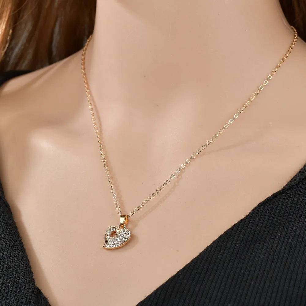 Gold electroplated alloy women's jewellery set with love, water drop, and bell patterned earrings, pendant, and bracelet.