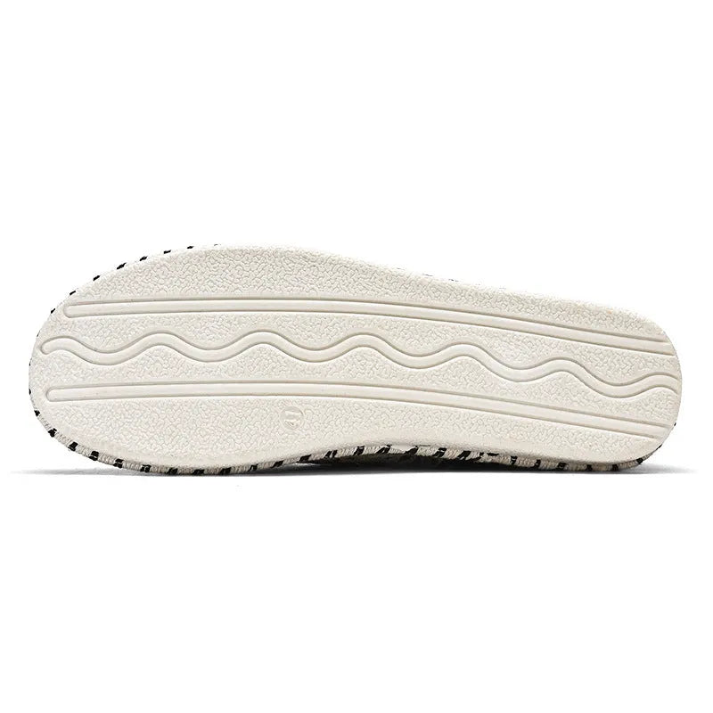 Men's round toe casual cloth shoes in beige and black on a plain background.