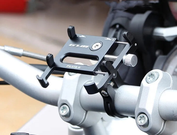 Black aluminium alloy GUB motorcycle phone holder mounted on bicycle handlebars, showing phone clamp.