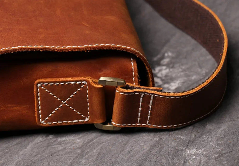 Vintage brown men's shoulder bag made of cowhide leather with adjustable strap and multiple internal pockets.