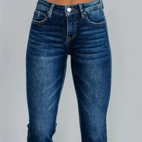 Women's hand-worn denim trousers in dark blue, showing 100% cotton fabric and casual fit