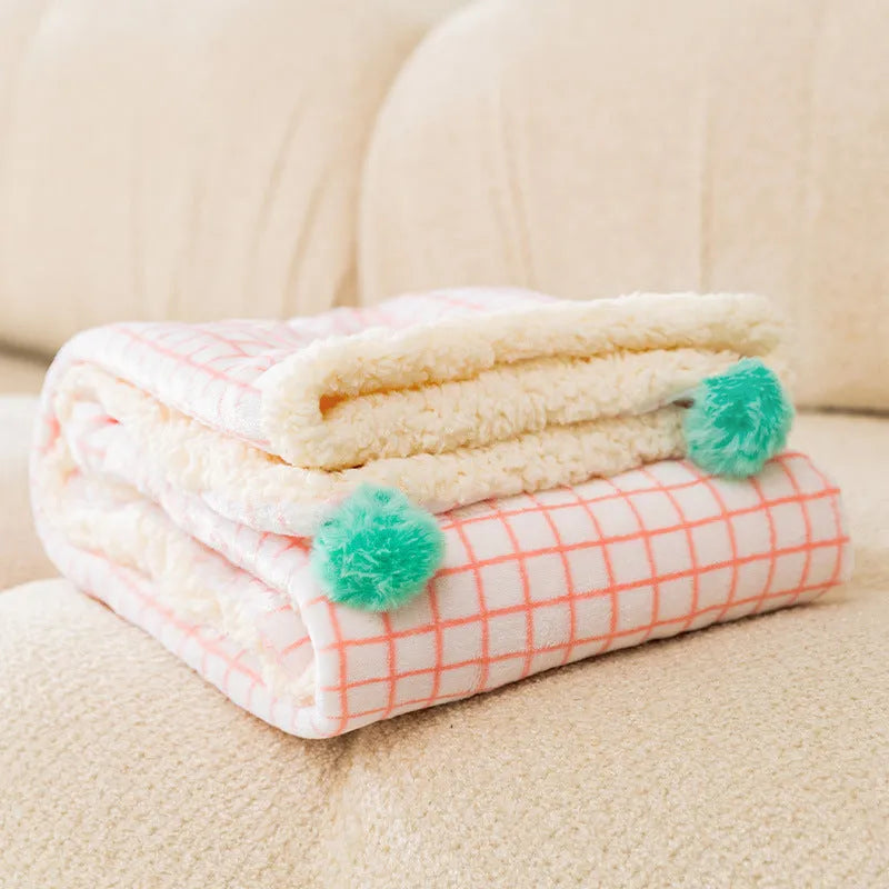 Blue coral fleece pet blanket for dog or cat on a wooden floor.