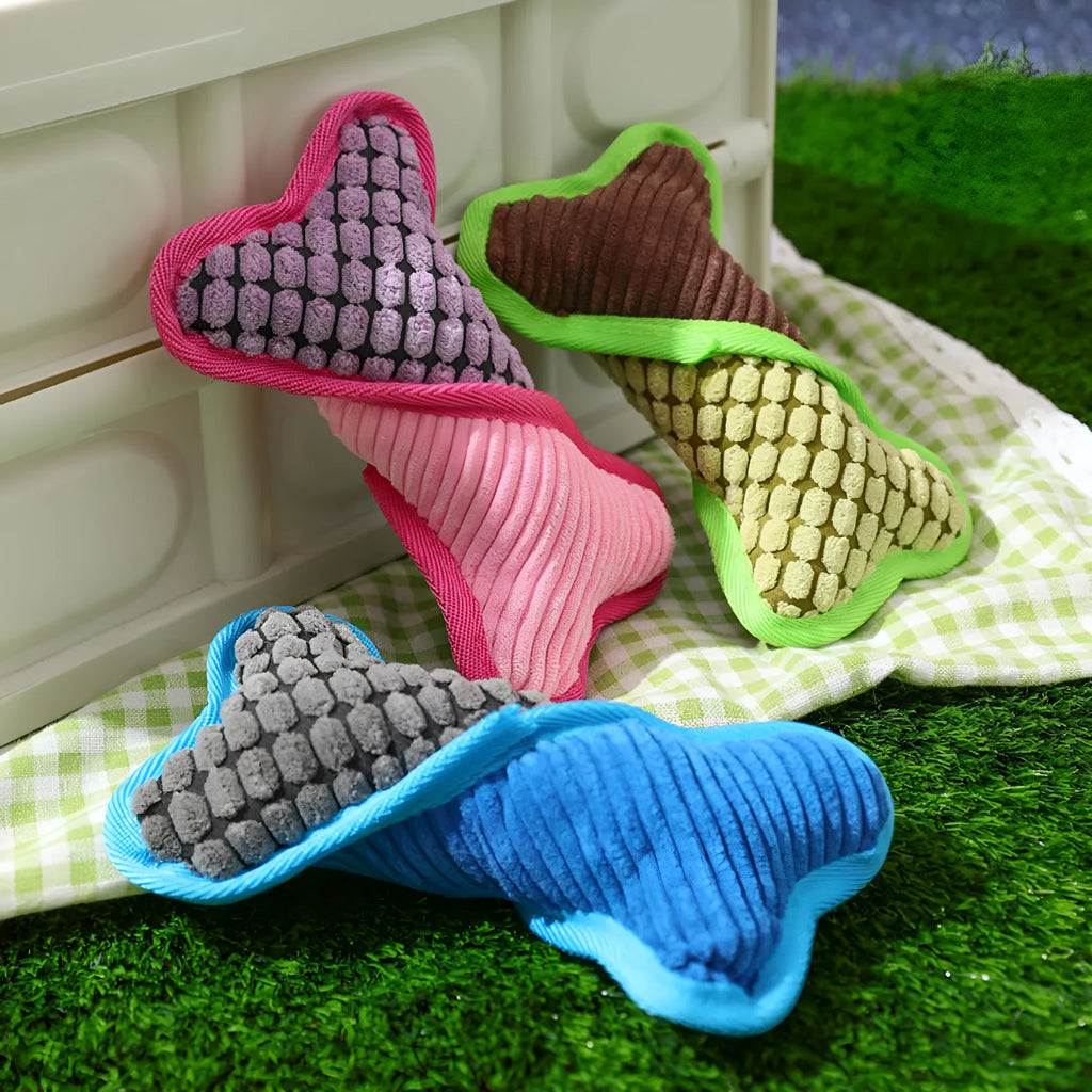 Blue, green, and pink plush dog bone toys with squeakers and soft corn fleece lining.