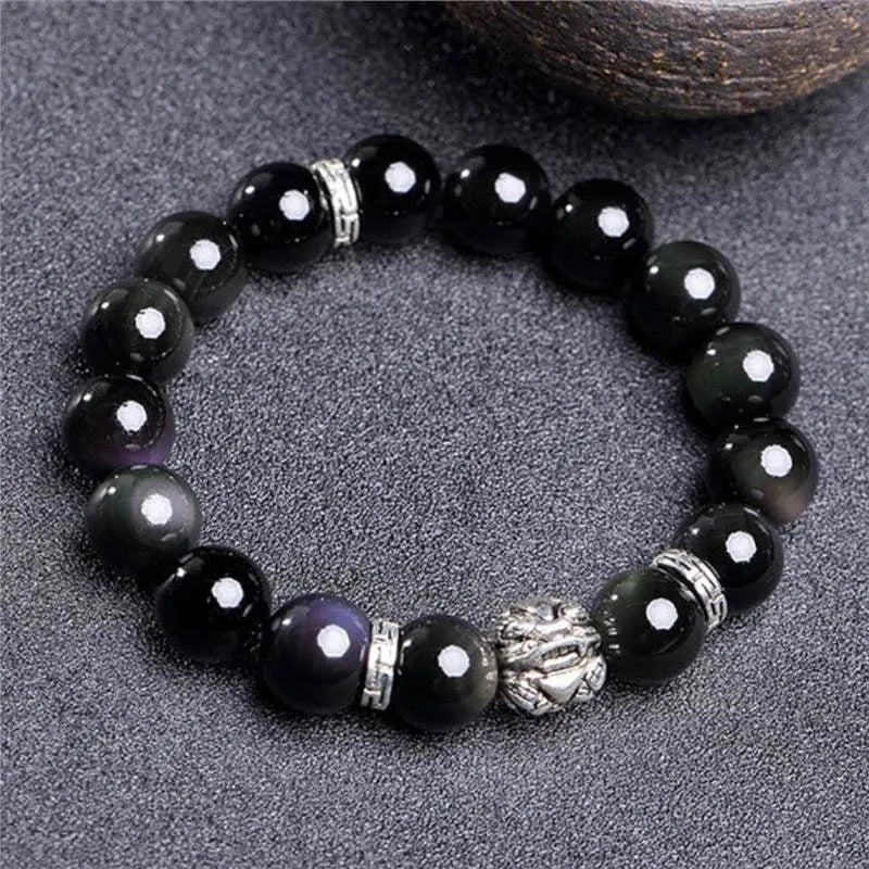 Natural obsidian and 999 silver unisex bracelet on a wrist, showing 10mm or 12mm bead size options.