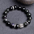 Natural obsidian and 999 silver unisex bracelet on a wrist, showing 10mm or 12mm bead size options.
