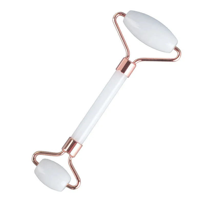 White jade facial roller with double-headed design and optional gua sha board on wooden surface