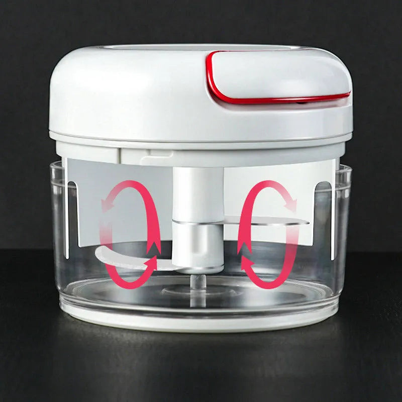 White manual food chopper with stainless steel blades on a magnetic holder, shown with chopped vegetables.