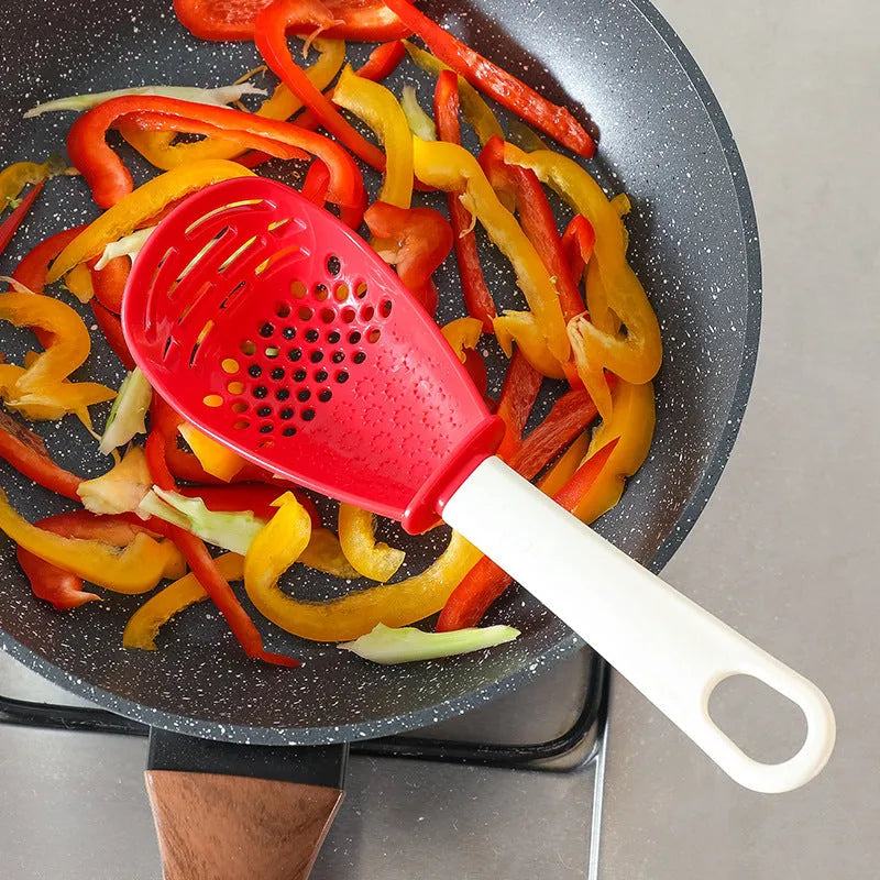 Red and black multifunctional slotted spoon with grinding serrations and half-enclosed head for kitchen use