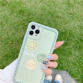 Green TPU iPhone case with geometric smiley face and polka dot frame designs on a table