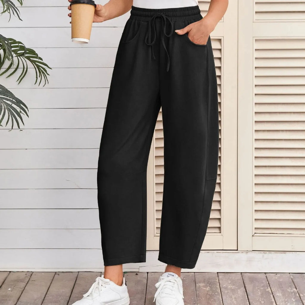 Loose sports cropped sweatpants in hot light grey with elastic waist and drawstring, showing collage/stitching craft details