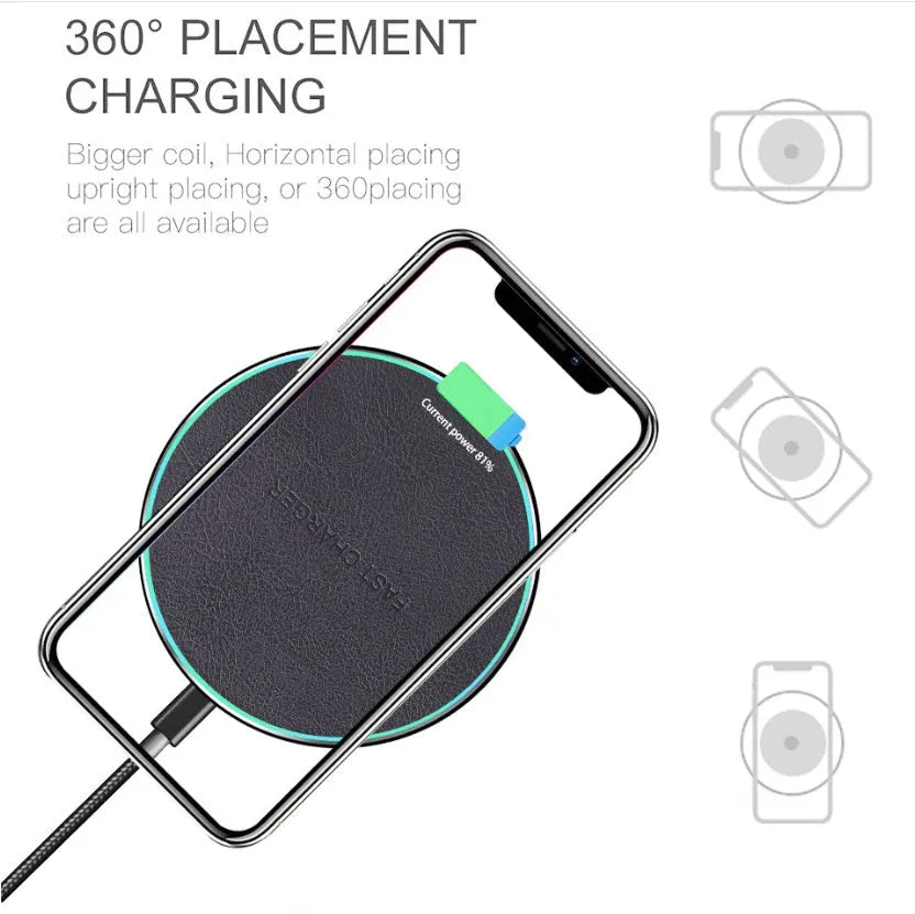 Black Quick Qi wireless charging pad for iPhone 11 on a wooden desk.