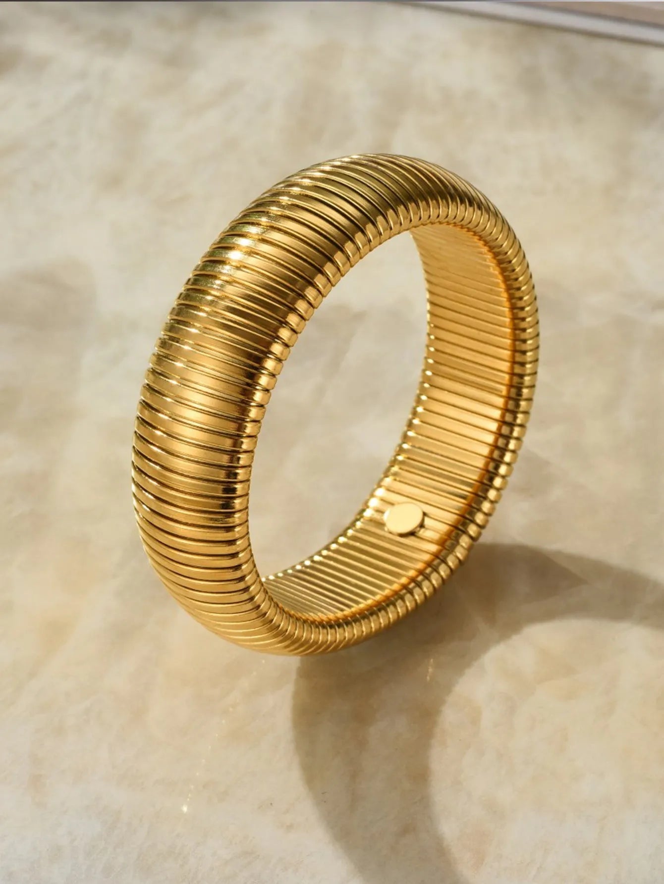Women's elastic titanium steel bracelet with vertical stripe and ring design in gold or silver, showing adjustable width options.