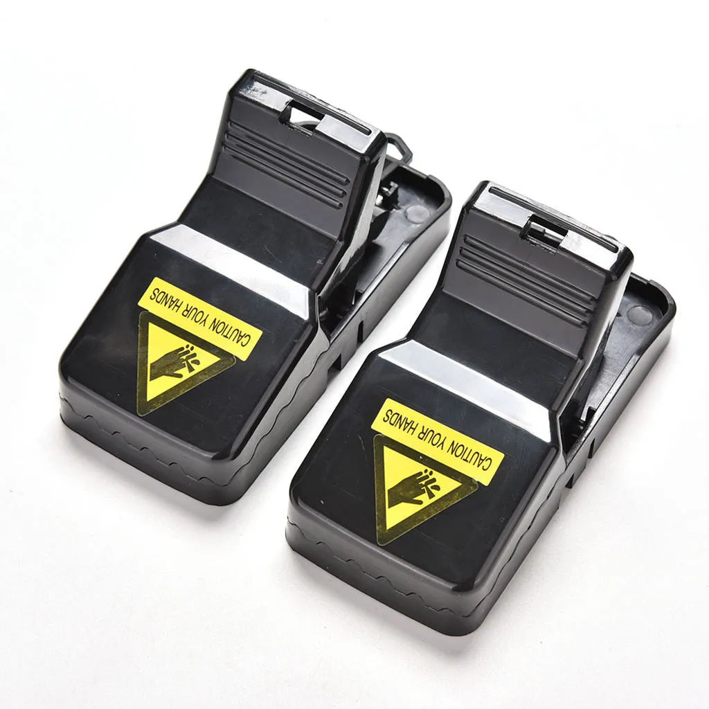 Six black plastic snap mousetraps showing smooth surface and compact size