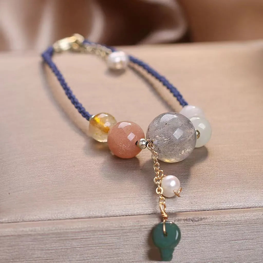 Women's hand-woven crystal and sequin bracelet with a silver peace buckle fastening on a wrist.